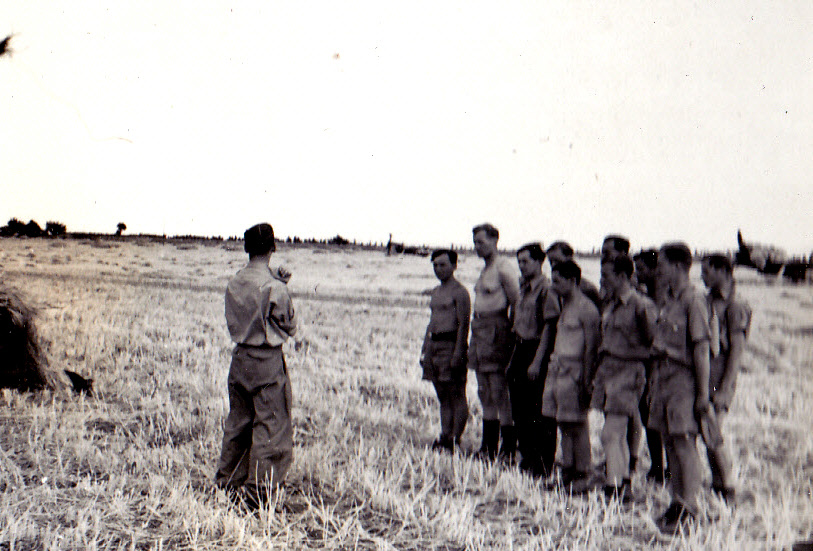 Poldi Wenger talks to a group on the airfield in Sicily in June 1943.