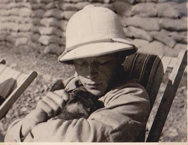 Unteroffizier Deinzer with a puppy, and wearing the white tropical helmet issued for the heat of southern France