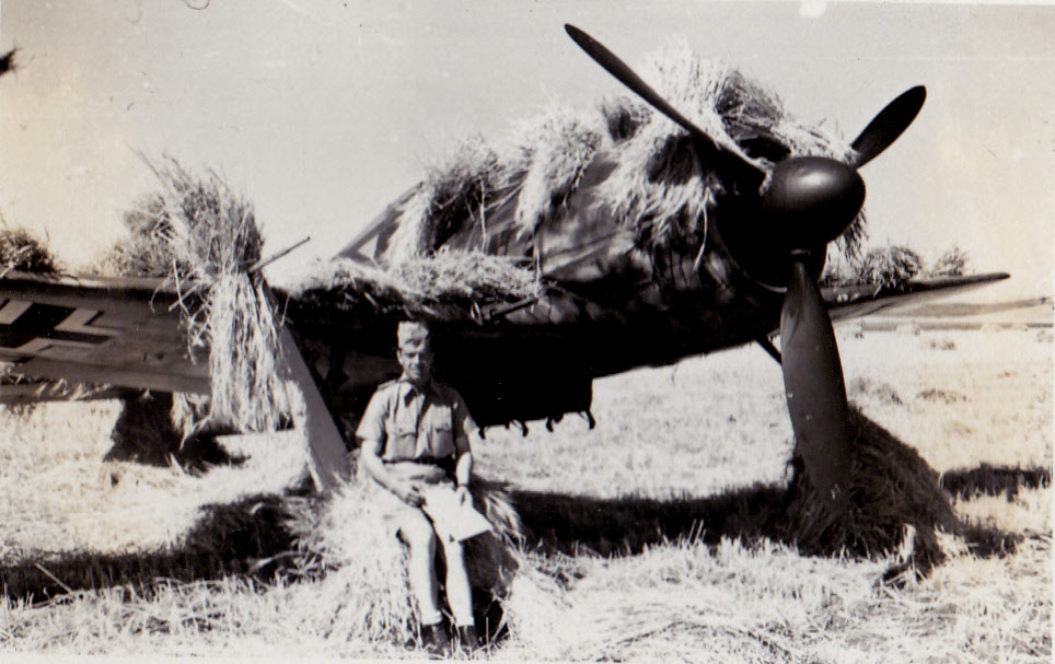 Oberleutnant Holzapfel sitting by his grass-covered plane two days before he was killed. July 1943, Sicily.