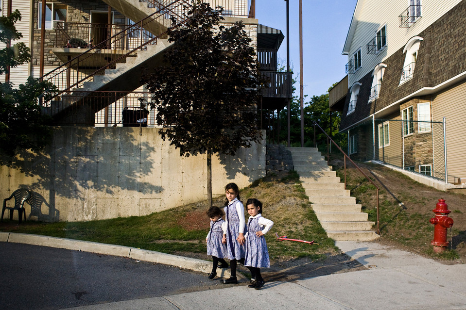 Orthodox sisters wait for school bus in Kiryas Joel. 