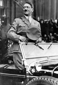 Hitler standing in car.