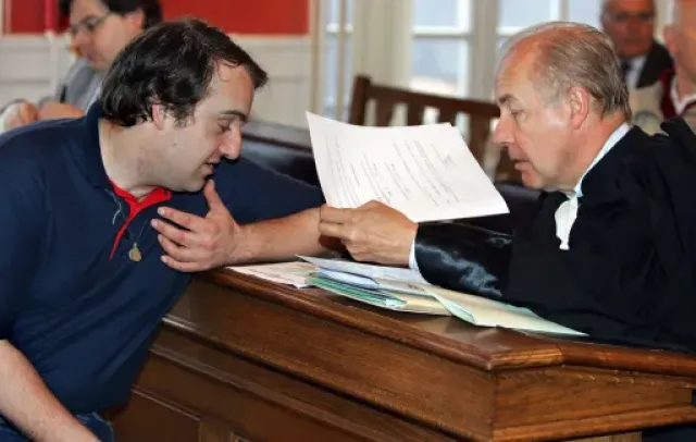Vincent Reynouard consulting his lawyer during one of his many court appearances in France.